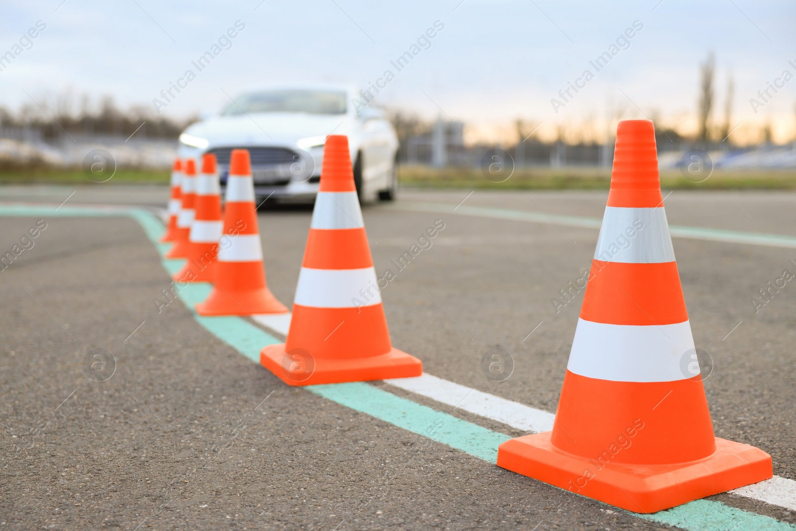 Photo of Modern car at test track, focus on traffic cone. Driving school