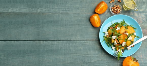 Delicious persimmon salad served on light blue wooden table, flat lay with space for text. Banner design