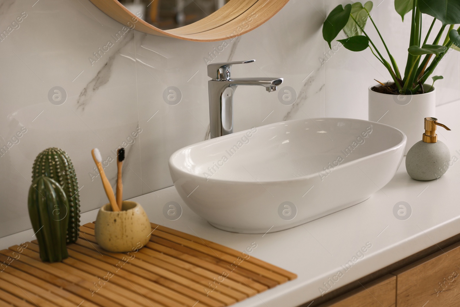 Photo of Stylish vessel sink on light countertop in modern bathroom