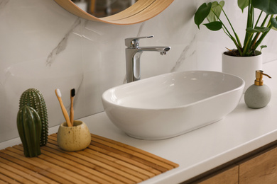 Stylish vessel sink on light countertop in modern bathroom