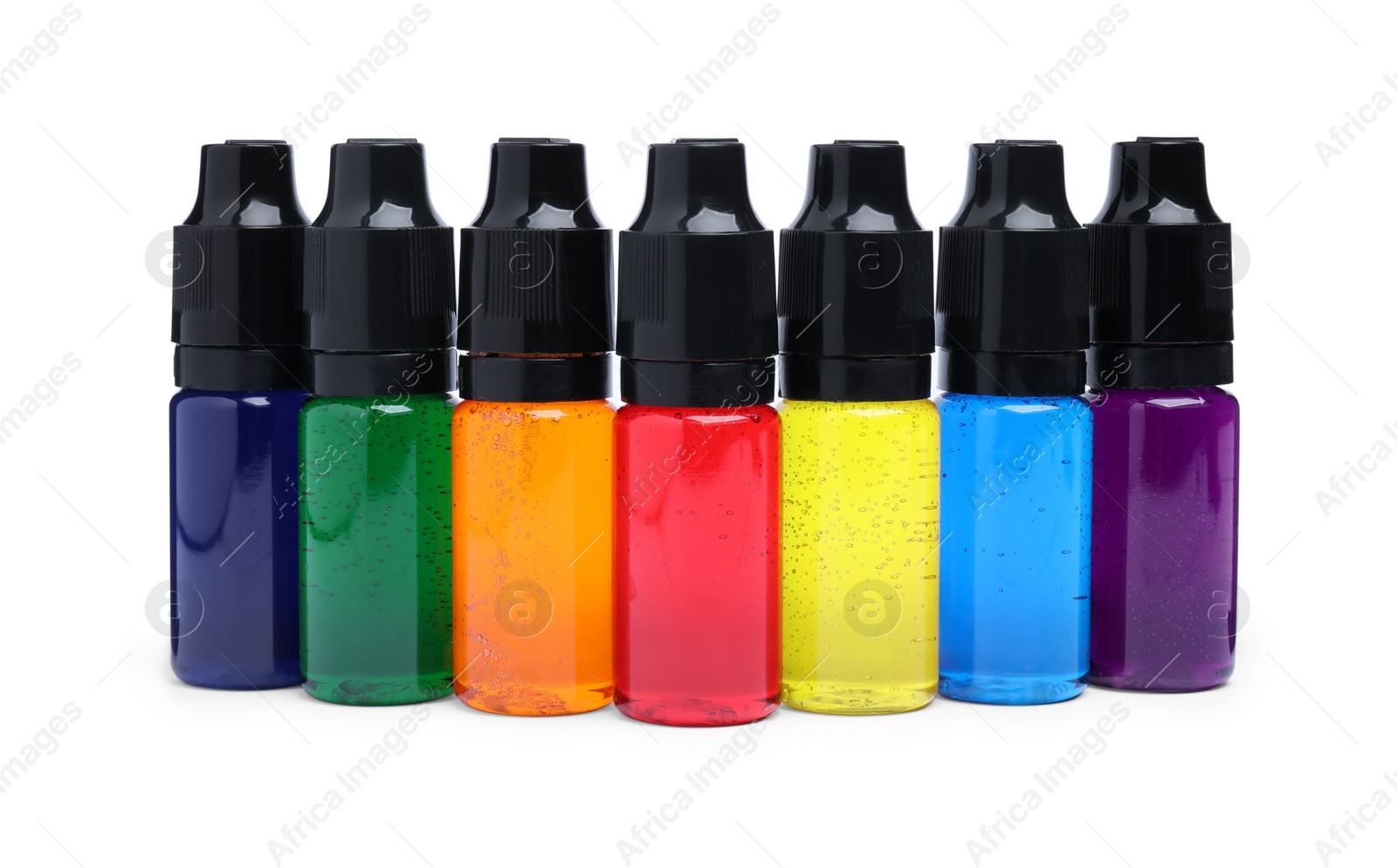 Photo of Bottles with different food coloring on white background