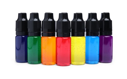 Photo of Bottles with different food coloring on white background