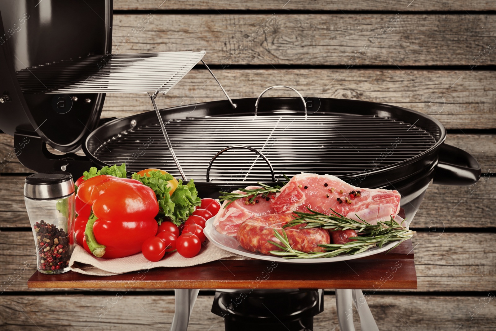 Image of Barbecue grill with meat products and vegetables on wooden background, closeup