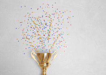 Photo of Trophy and confetti on light background, top view with space for text. Victory concept