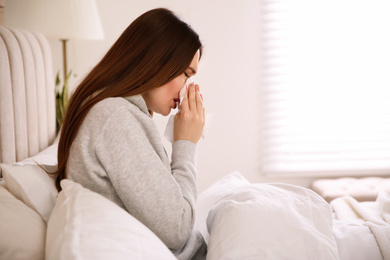 Photo of Sick young woman in bed at home. Influenza virus