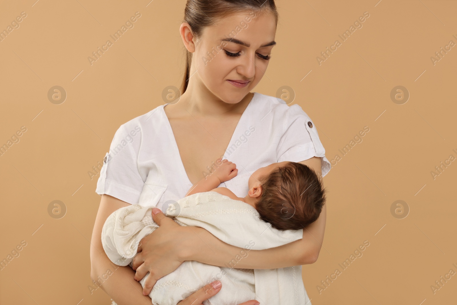 Photo of Mother with her cute newborn baby on beige background