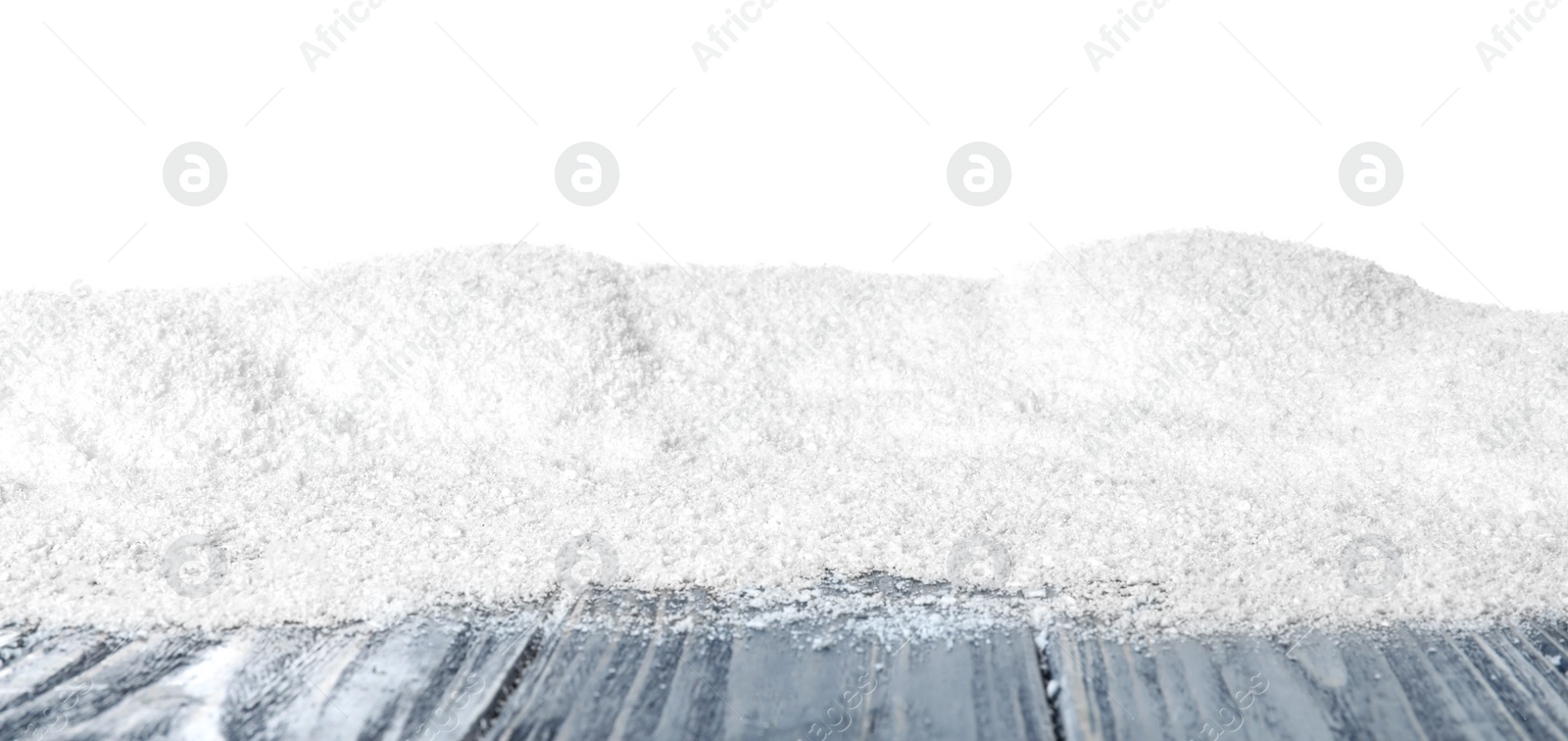Photo of Heap of snow on grey wooden surface against white background