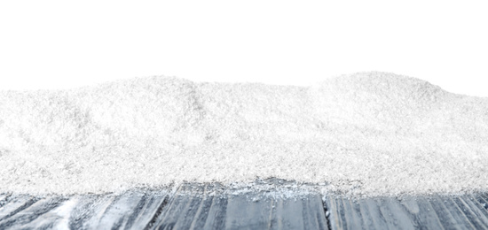 Heap of snow on grey wooden surface against white background