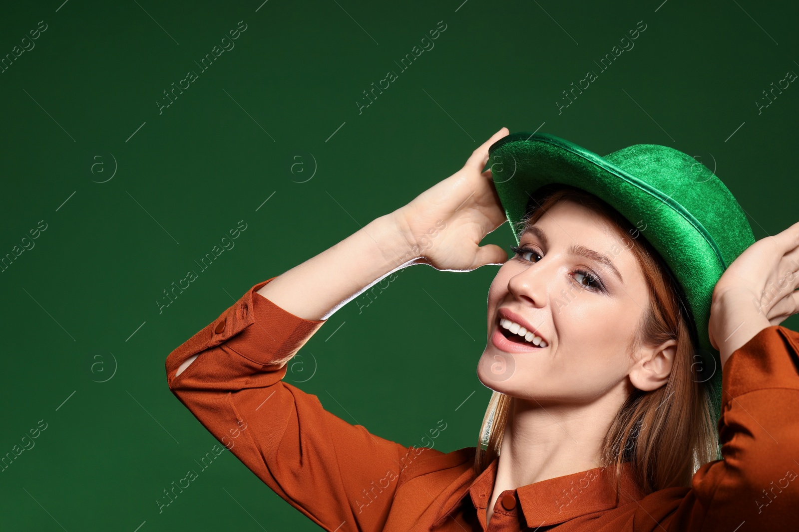 Photo of Young woman in green hat on color background. St. Patrick's Day celebration