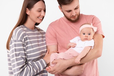 Happy family. Parents with their cute baby on light background