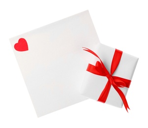 Blank card, gift box and red decorative heart on white background, top view. Valentine's Day celebration