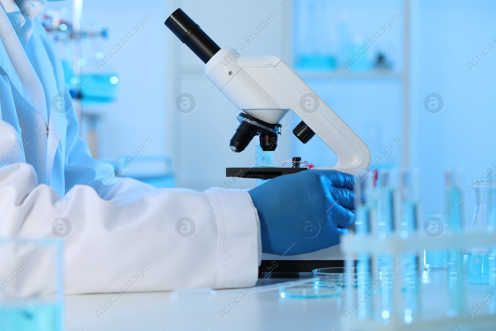 Photo of Scientist working with microscope in laboratory, closeup. Medical research