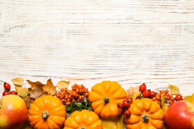 Flat lay composition with ripe pumpkins and autumn leaves on white wooden table, space for text. Happy Thanksgiving day