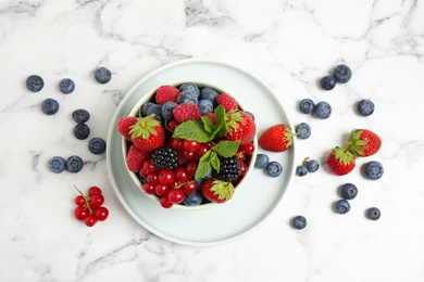 Mix of ripe berries on white marble table, flat lay