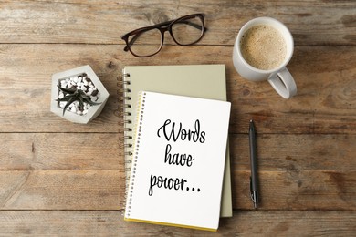 Image of Notepad with phrase Words Have Power, pen, glasses, potted plant and coffee on wooden table, flat lay