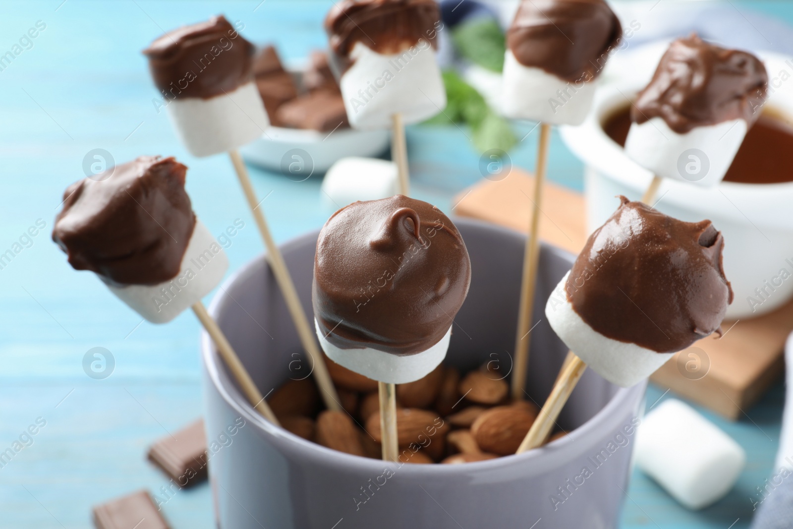 Photo of Delicious marshmallows covered with chocolate in cup, closeup