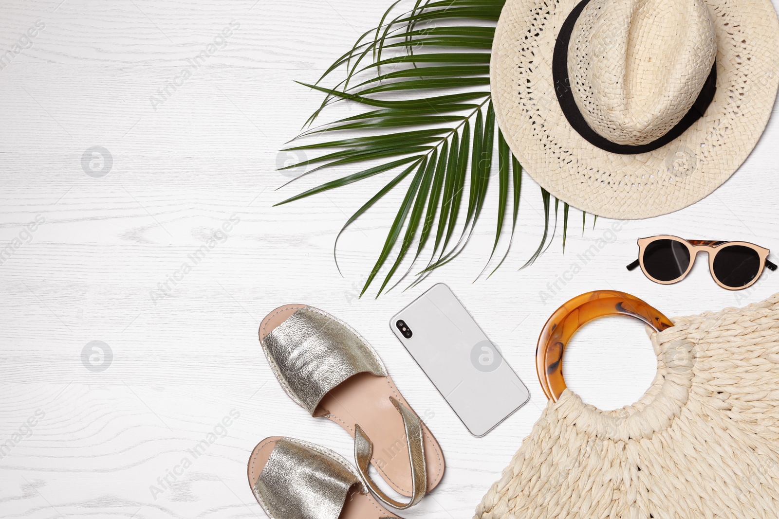 Photo of Flat lay composition with beach bag and accessories on white wooden background, space for text