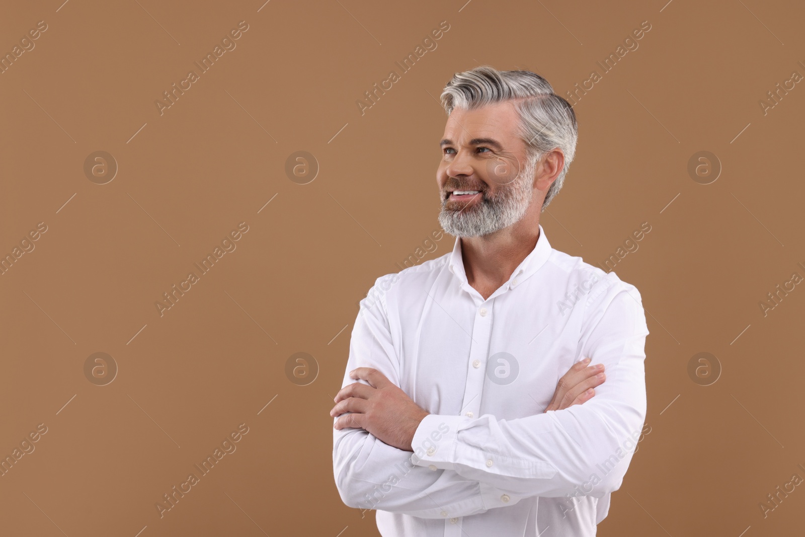 Photo of Portrait of smiling man with beautiful hairstyle on light brown background. Space for text
