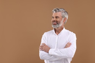 Portrait of smiling man with beautiful hairstyle on light brown background. Space for text