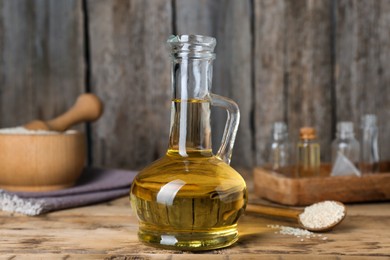 Photo of Fresh sesame oil and seeds on wooden table