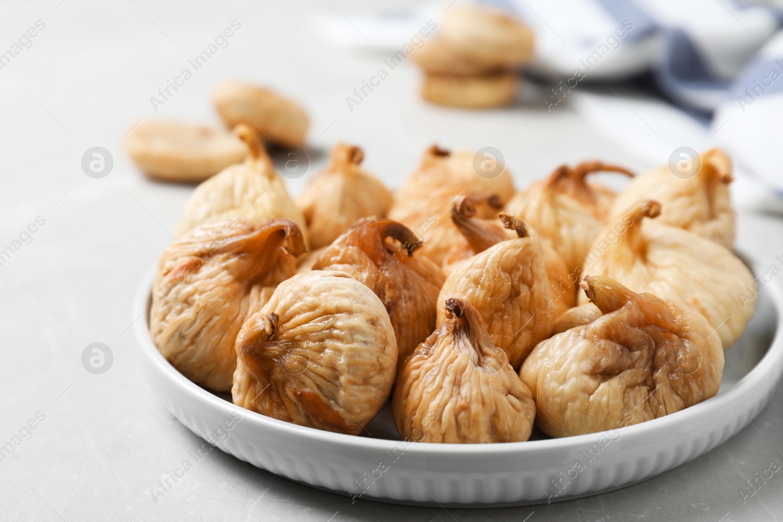 Photo of Tasty dried figs on light grey marble table, closeup