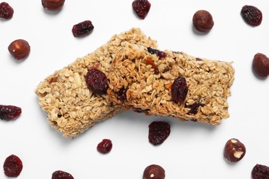 Photo of Tasty granola bars with dry cherries and nuts on white background, flat lay