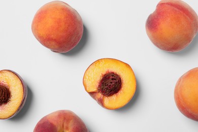 Photo of Cut and whole fresh ripe peaches on white background, flat lay