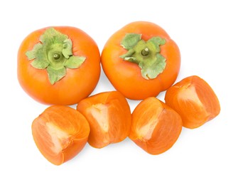 Whole and cut delicious ripe juicy persimmons on white background, top view