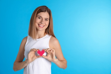 Photo of Portrait of woman with decorative heart on color background. Space for text