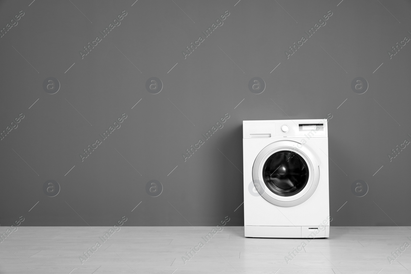 Photo of Empty washing machine near color wall, space for text. Laundry day