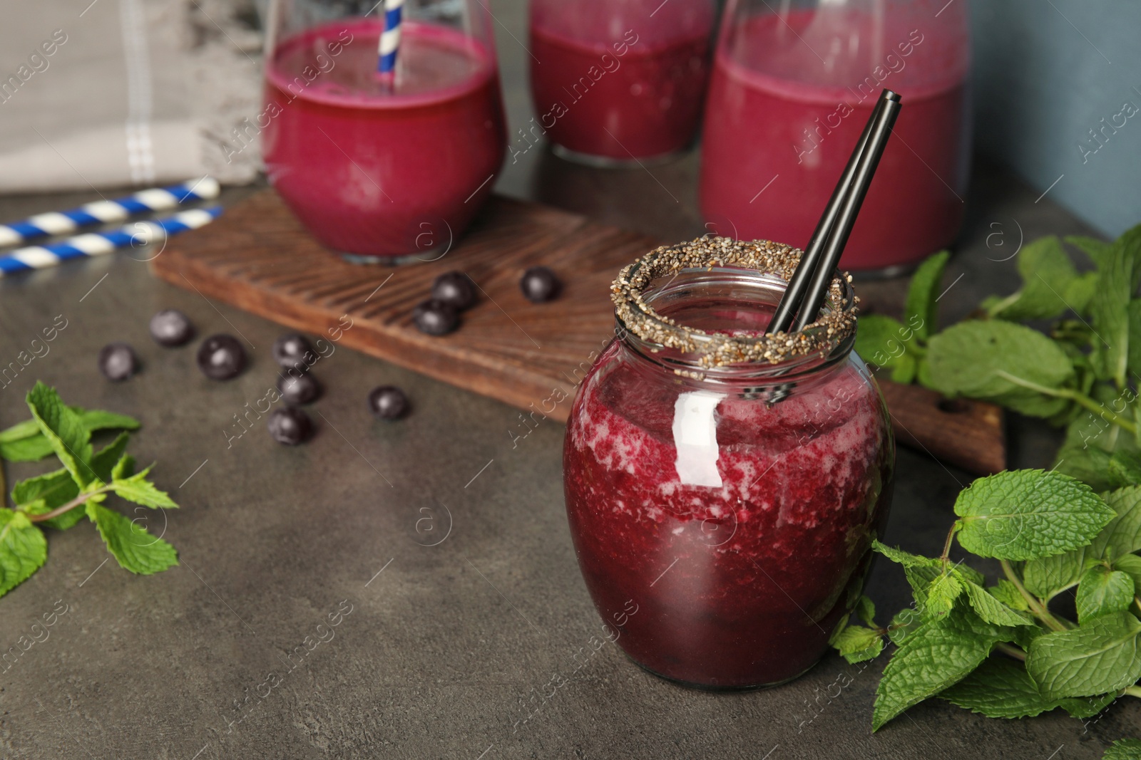 Photo of Composition with jar of acai juice on dark table