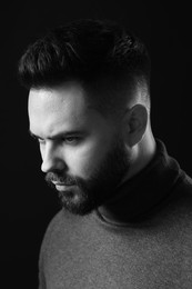 Portrait of handsome bearded man on dark background. Black and white effect