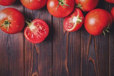 Photo of Fresh ripe tomatoes on wooden table, flat lay. Space for text