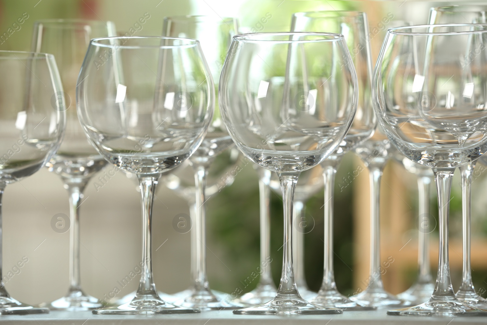 Photo of Empty glasses on table against blurred background