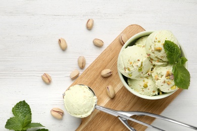 Tasty pistachio ice cream served on white wooden table, flat lay