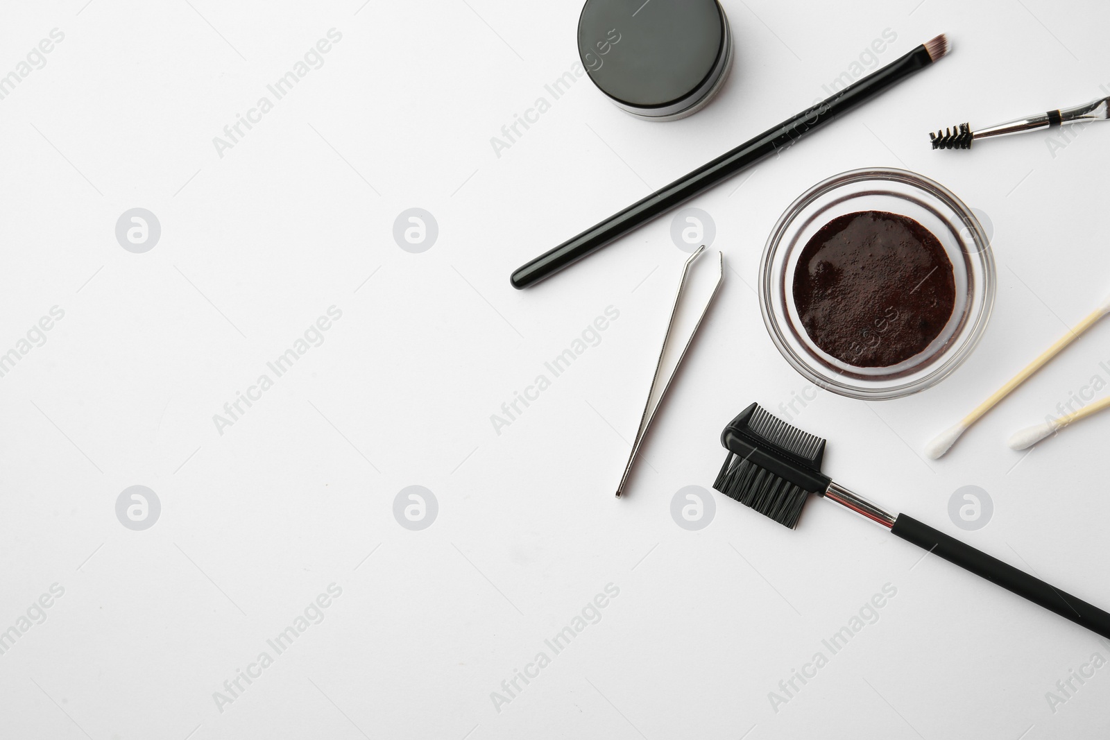 Photo of Flat lay composition with eyebrow henna and professional tools on white background, space for text