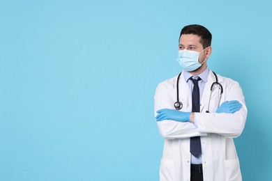 Photo of Doctor in medical mask on light blue background, space for text