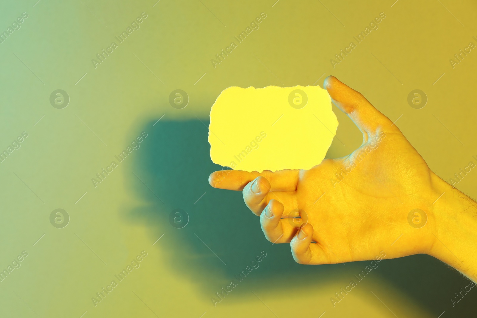 Photo of Man holding sheet of paper on color background, closeup and space for text. Color tone effect