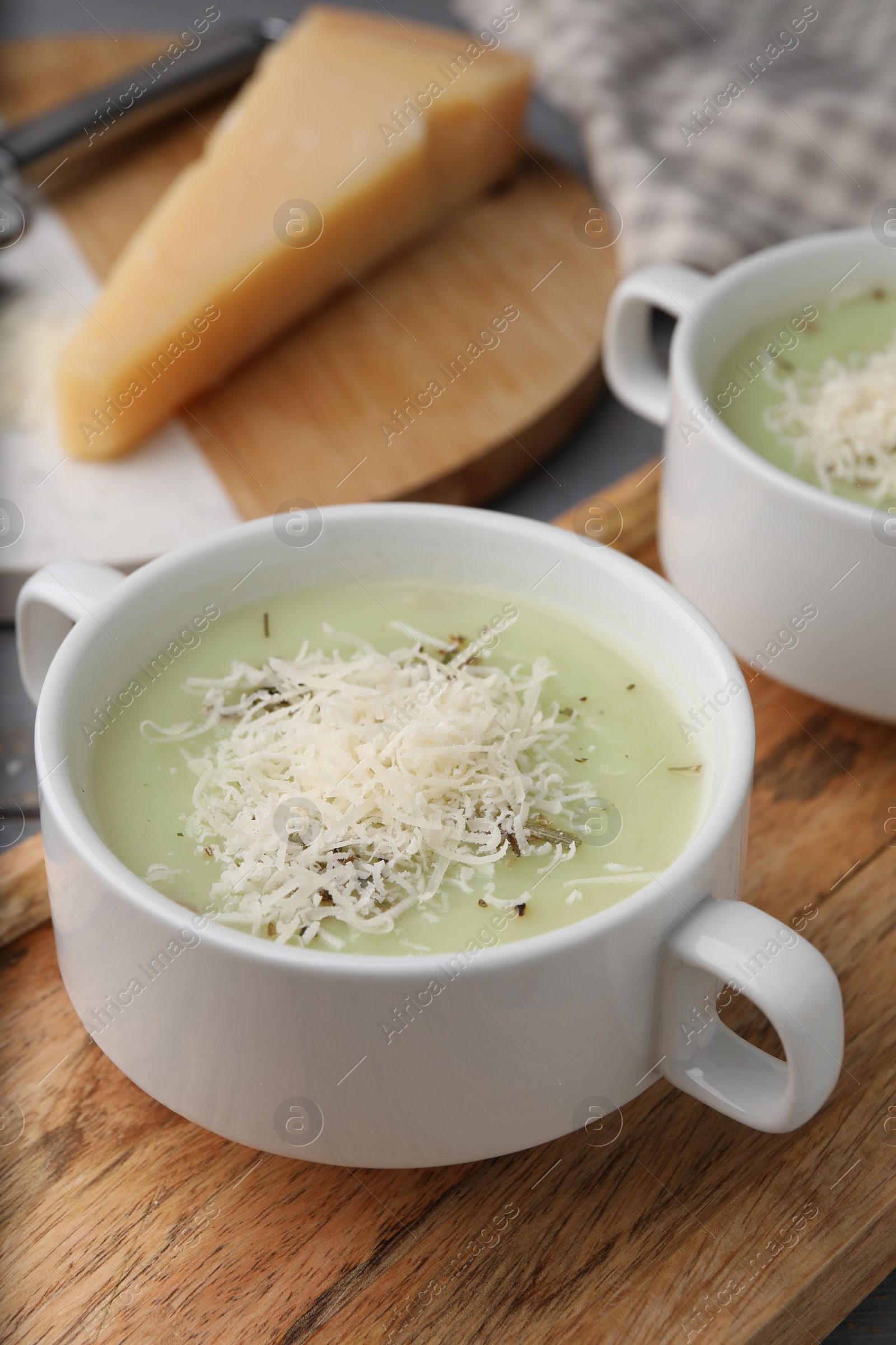 Photo of Delicious cream soup with parmesan cheese in bowls on table