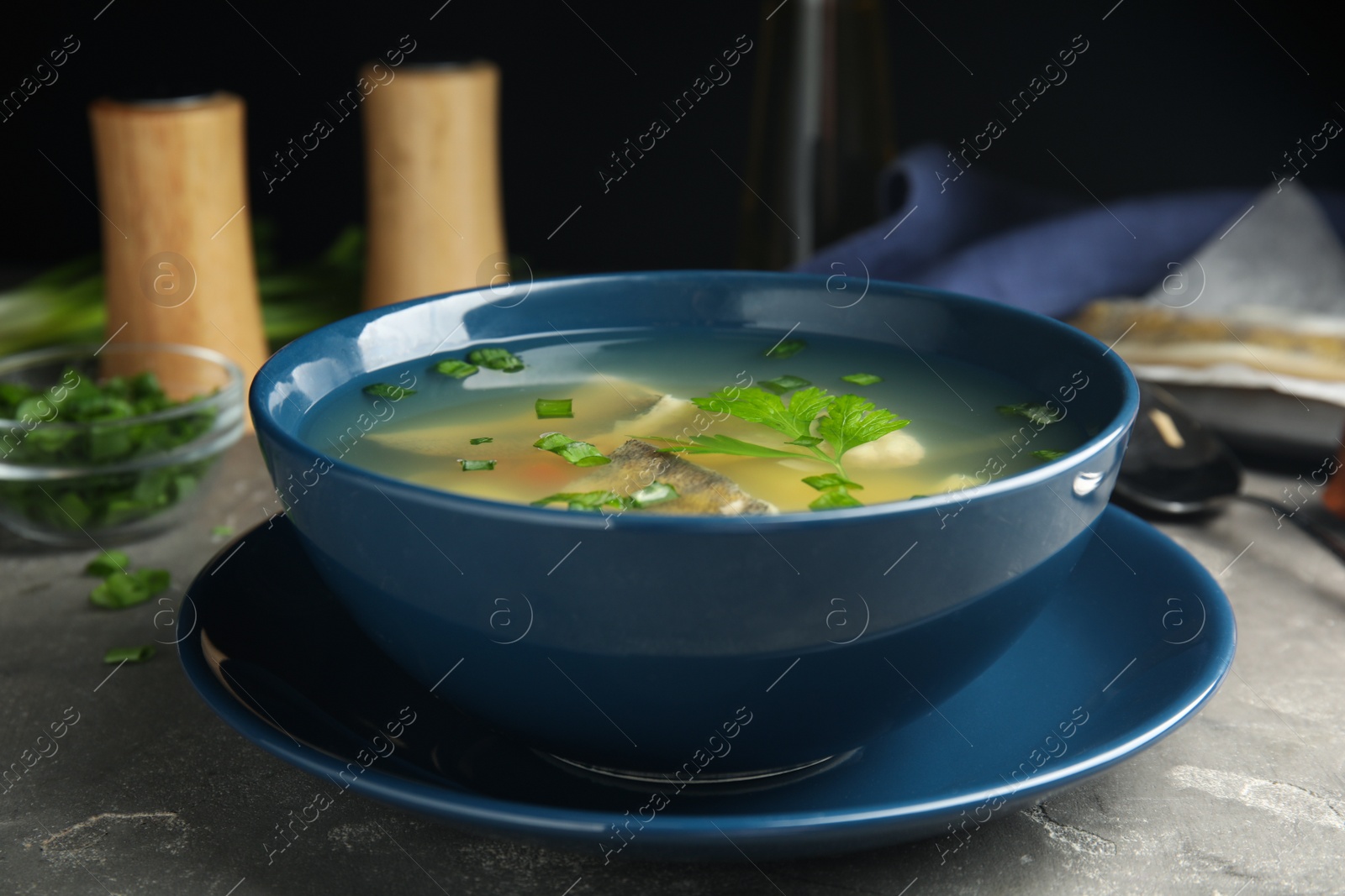 Photo of Delicious fish soup served on grey table, closeup