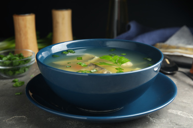 Photo of Delicious fish soup served on grey table, closeup