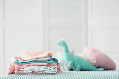 Photo of Pile of baby clothes on bed