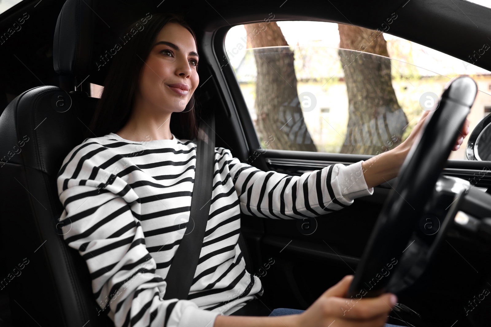 Photo of Woman with safety seat belt driving her modern car