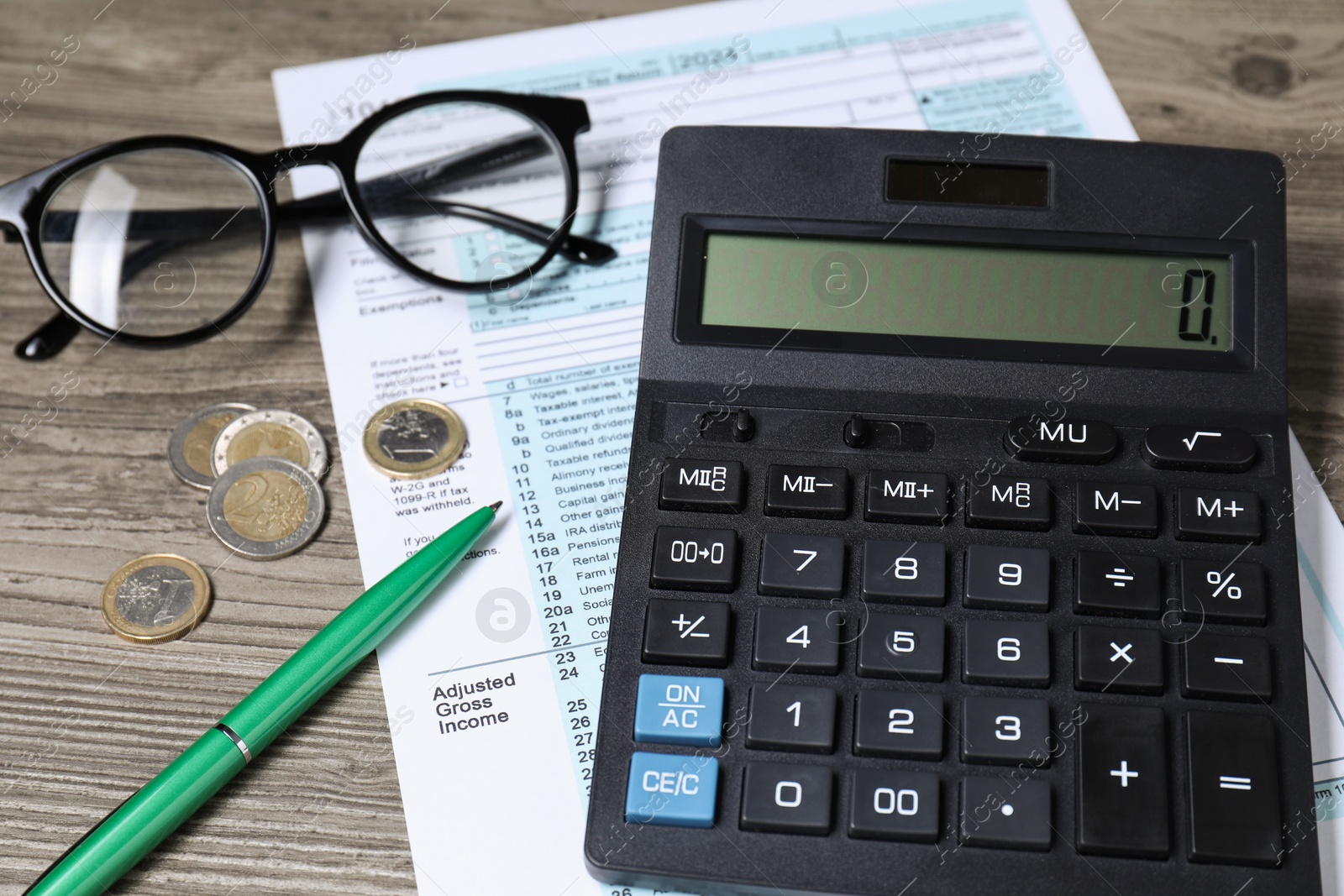 Photo of Tax accounting. Calculator, document, pen and coins on wooden table, closeup