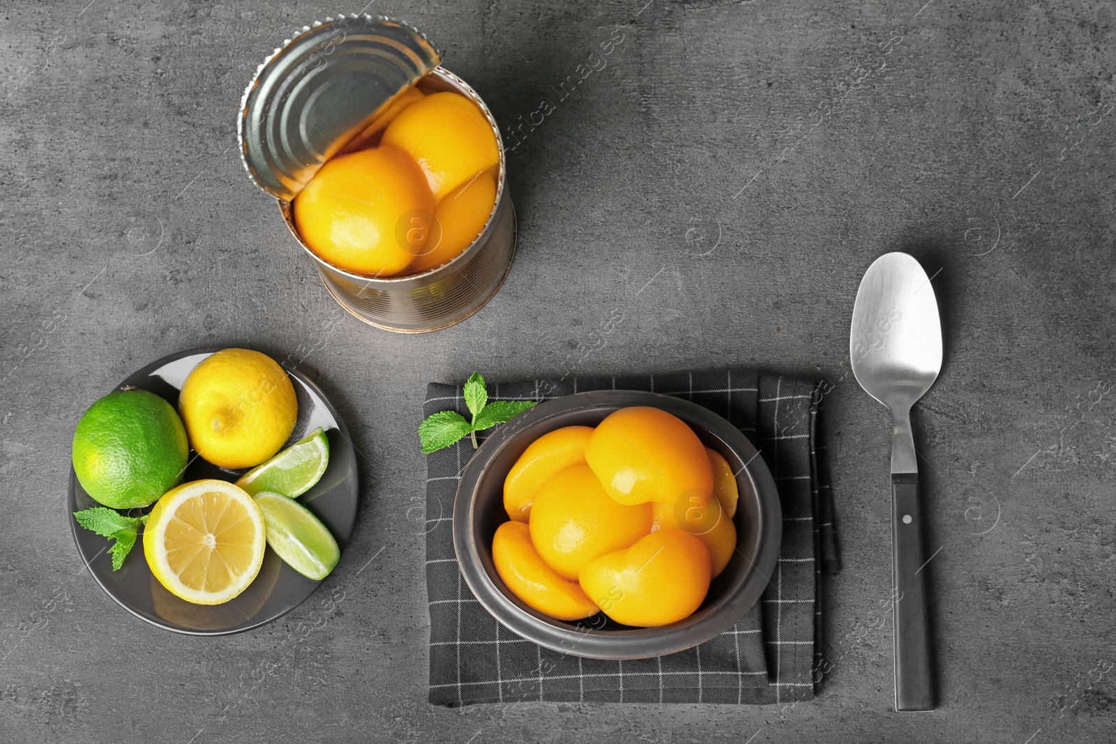 Photo of Flat lay composition with canned peaches on grey background