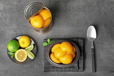 Flat lay composition with canned peaches on grey background