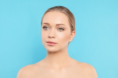 Portrait of young woman with beautiful face on blue background