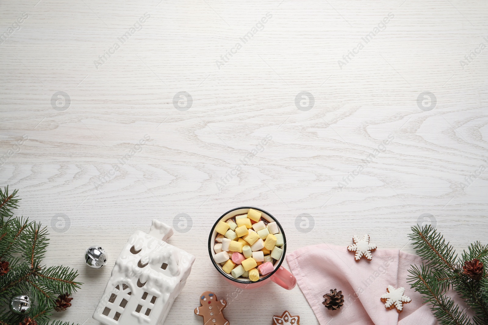 Photo of Delicious hot chocolate with marshmallows and Christmas decor on white wooden table, flat lay. Space for text