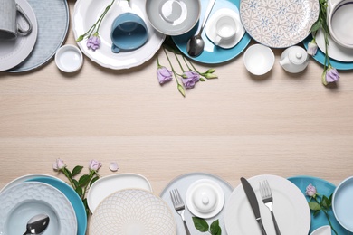 Photo of Flat lay composition with beautiful dishware and flowers on wooden table. Space for text