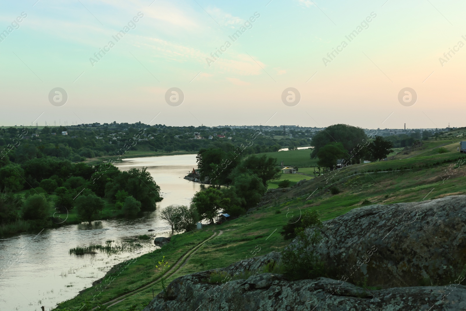 Photo of Picturesque landscape with river and green hills on summer evening